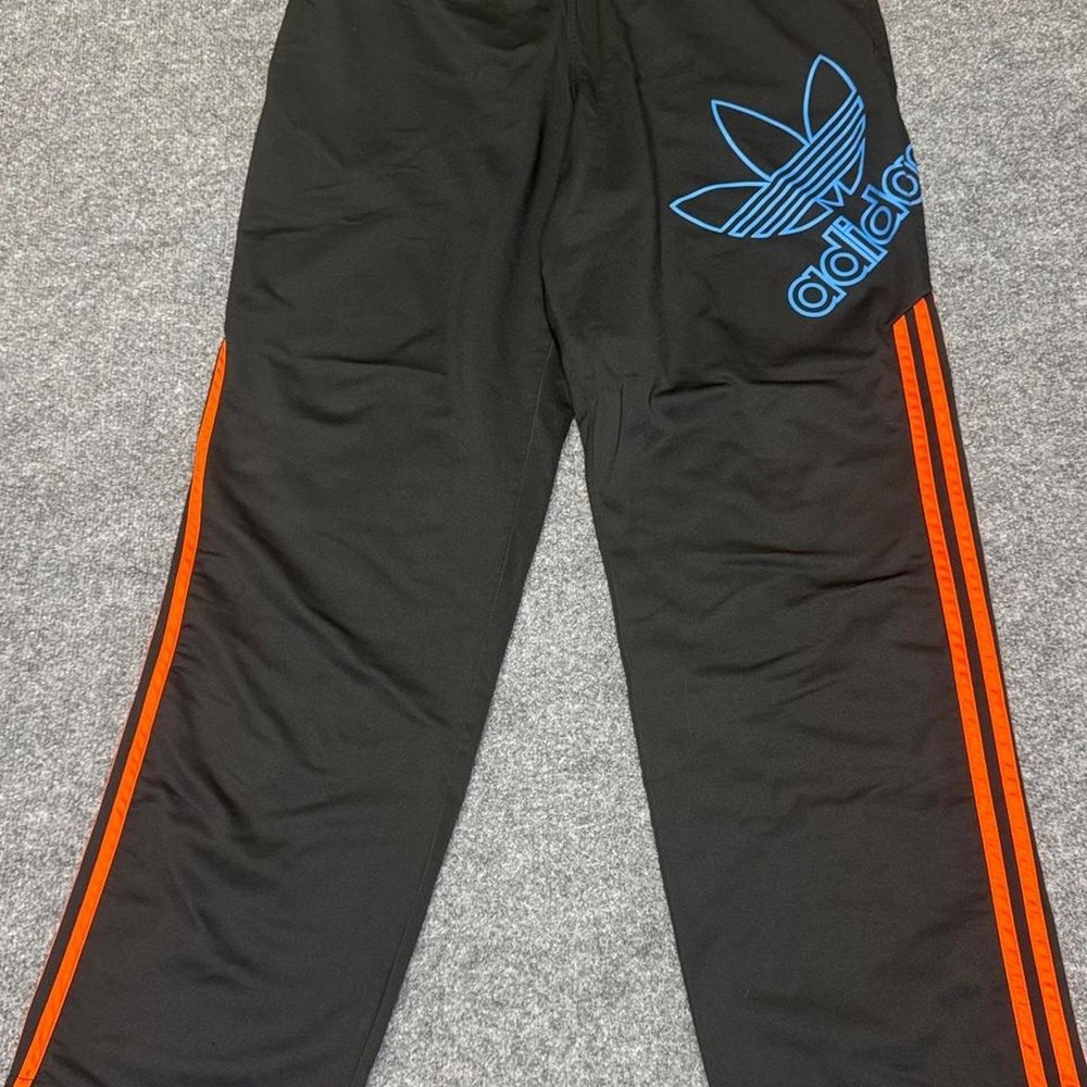 Adidas black track pants with orange stripes and blue Adidas logo, size L.